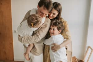 two parents hug two children
