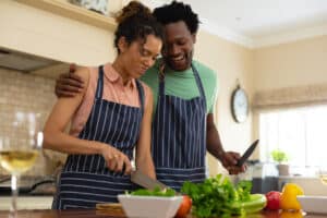 happy couple preparing meal together, practicing body and mind wellness